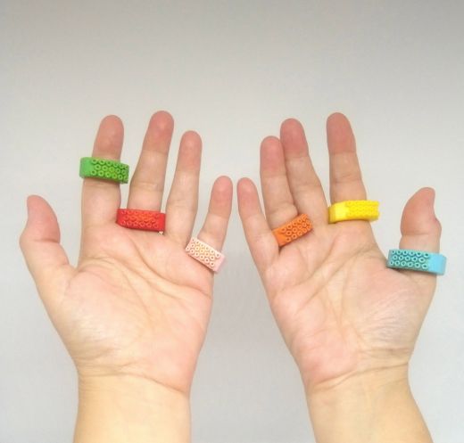 Primer plano de las palmas de las manos de una usuaria con tres anillos en cada mano
