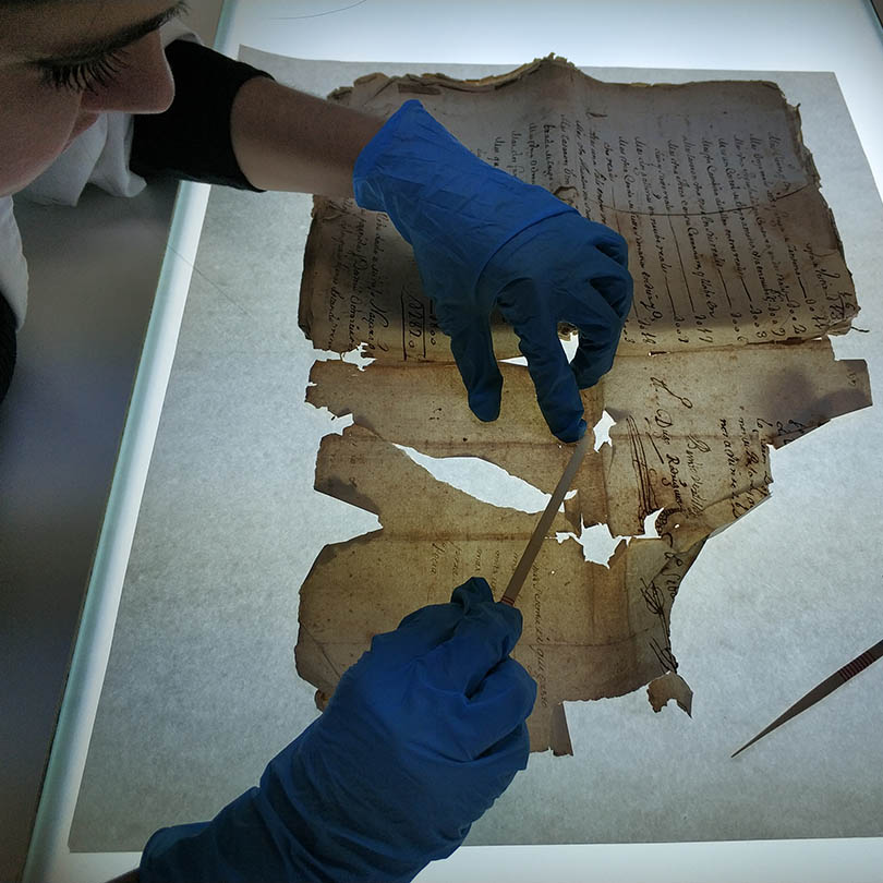 Restauradora trabajando en la restauración de un documento
